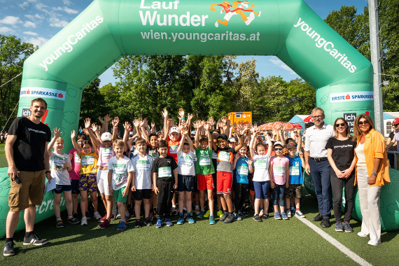 Kinder in Sportgewand strecken die Arme in die Luft