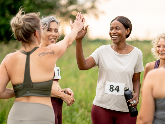 Frauen in Sportoutfits geben sich ein High Five