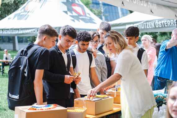 Schüler/innen informieren sich an einem Stand über diverse Lehrstellen